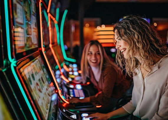 Girl friends gambling in casino on slot machinery