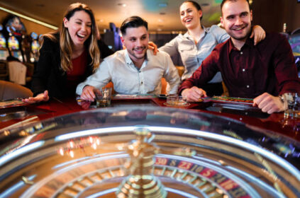 Excited group of friends playing roulette in casino